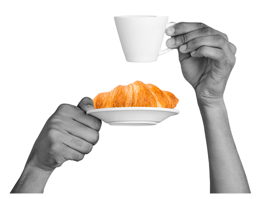 Mains tenant un café et un croissant